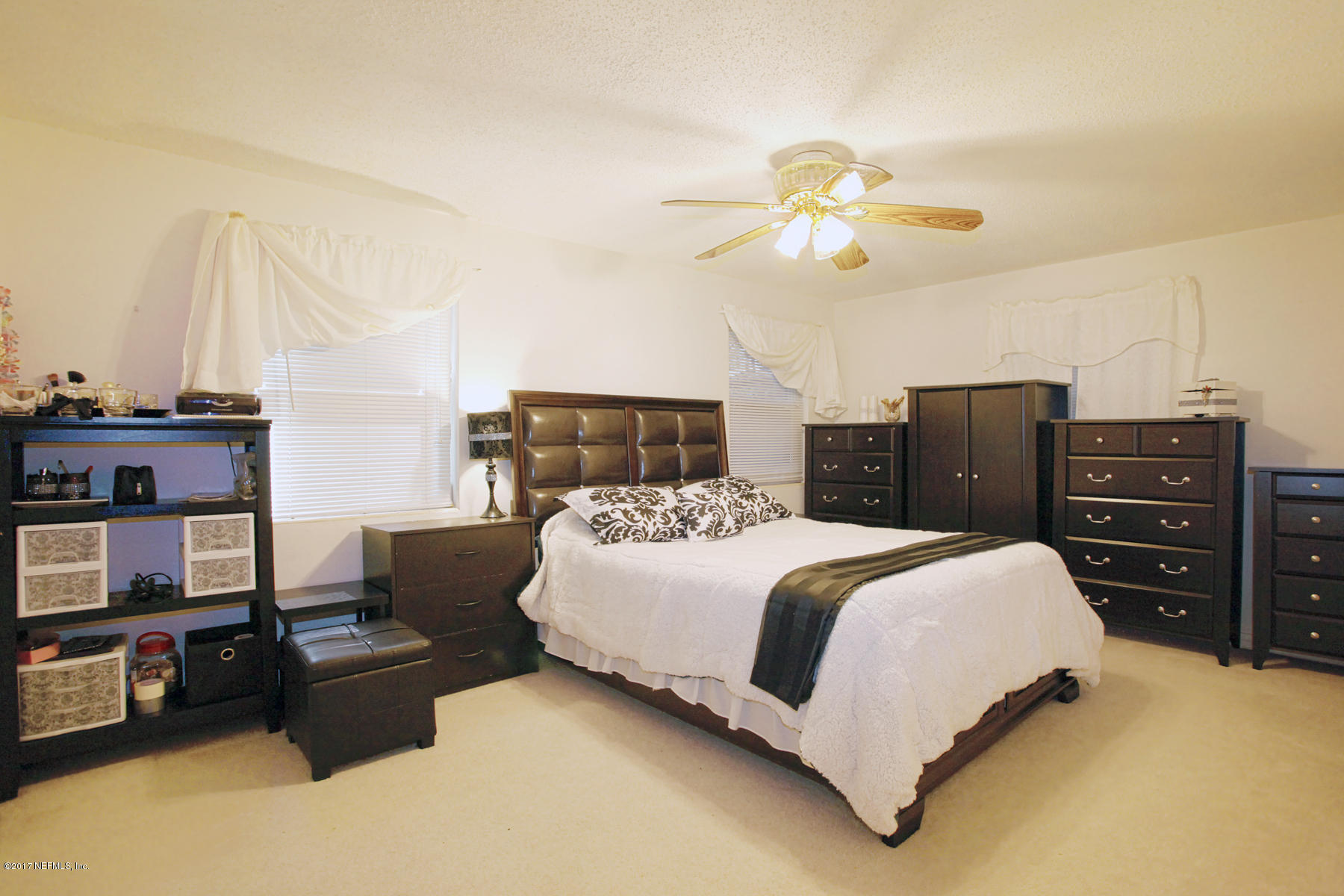4956 Spring Glen Road Jacksonville, FL 32207 - Photo 15 of 23 a bedroom with a bed and dresser