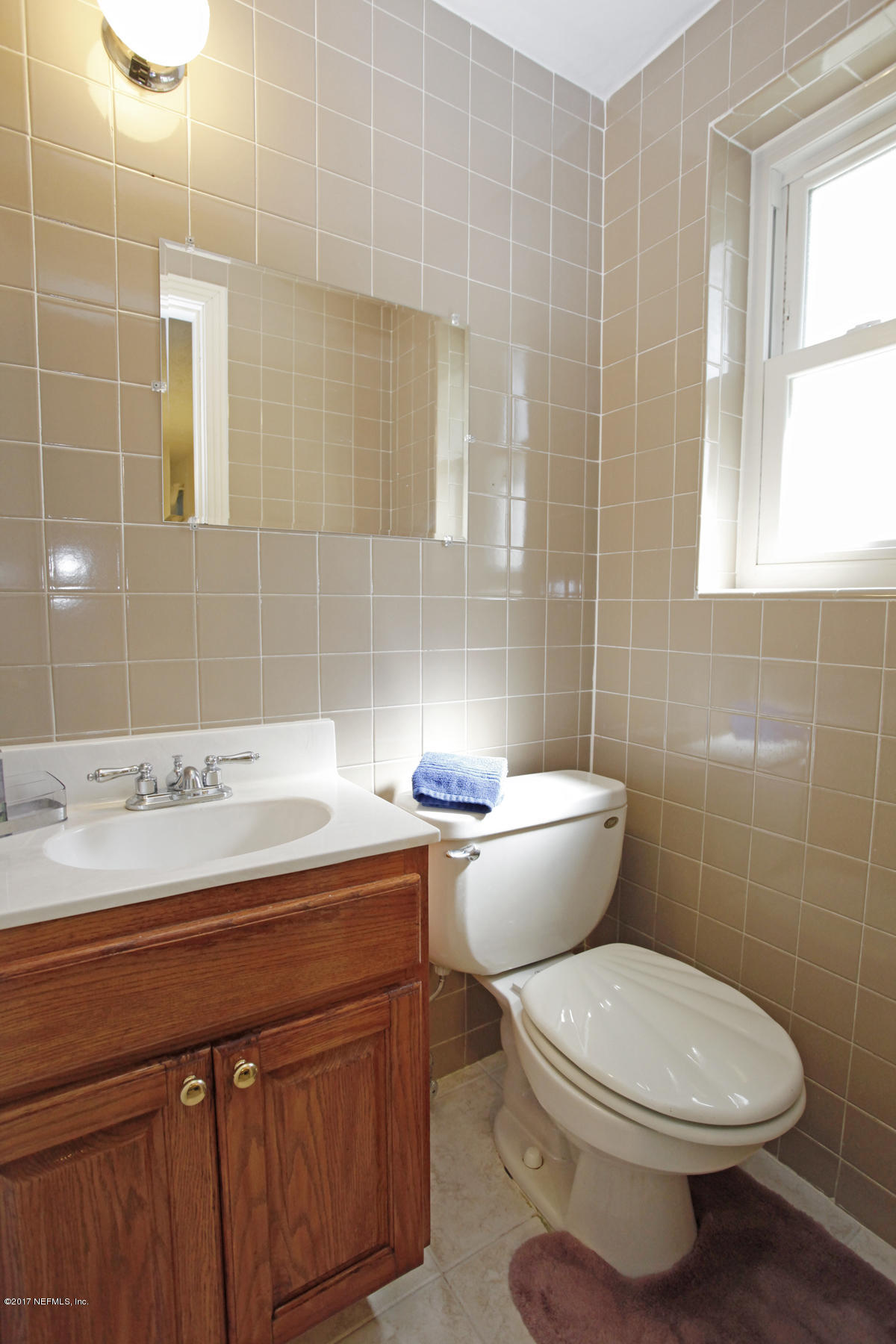 4956 Spring Glen Road Jacksonville, FL 32207 - Photo 16 of 23 a bathroom with a sink toilet and mirror
