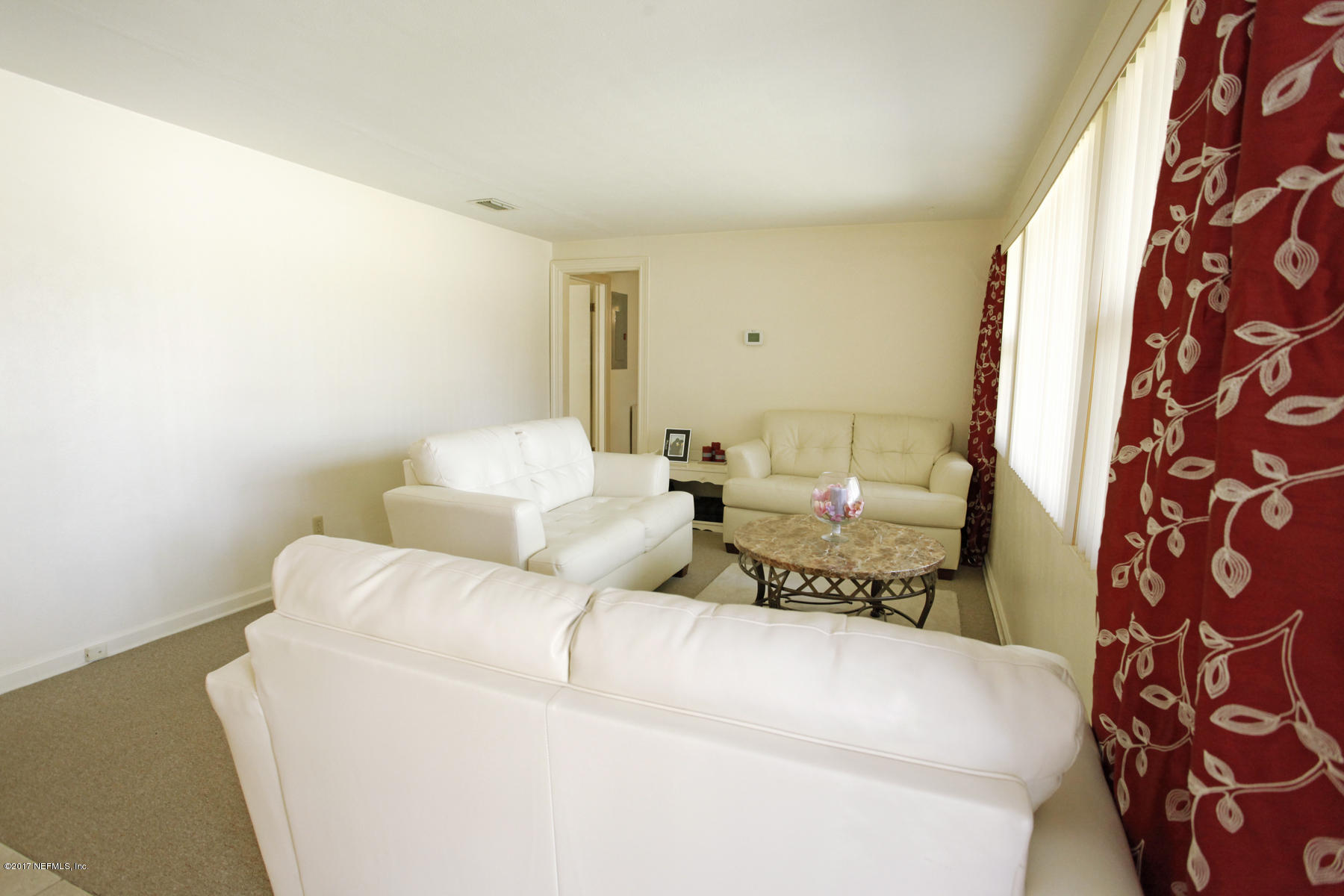 4956 Spring Glen Road Jacksonville, FL 32207 - Photo 3 of 23 a living room with a couch and a lamp