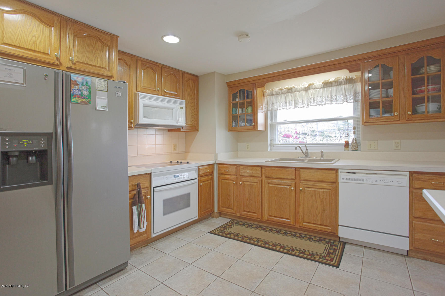 4956 Spring Glen Road Jacksonville, FL 32207 - Photo 6 of 23 a kitchen with cabinets appliances and a window