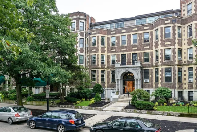 a couple of cars parked in front of a building