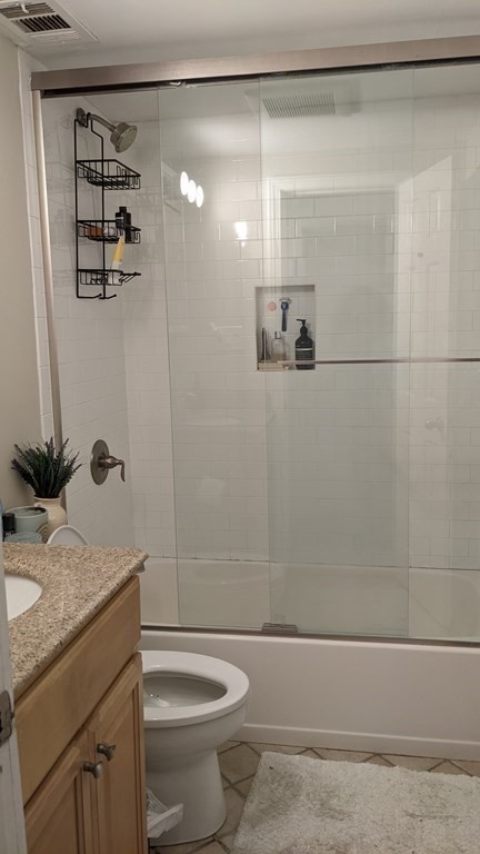 390 Riverway, Unit 1 Boston, MA 02115 - Photo 11 of 12 a bathroom with a granite countertop sink a toilet and shower