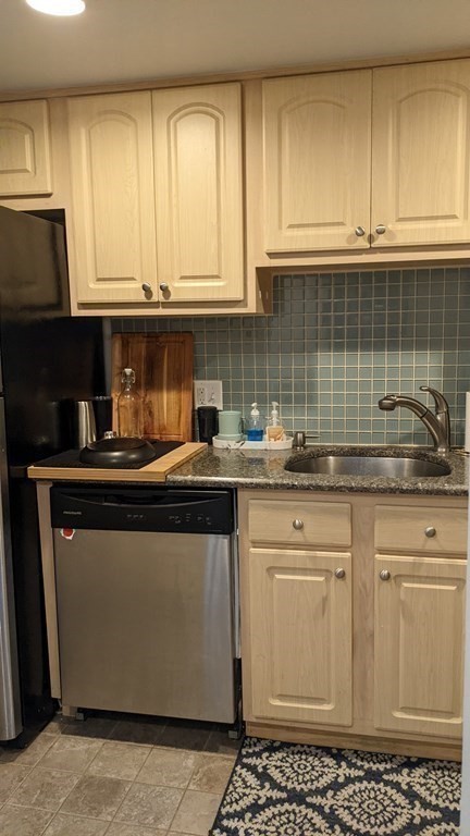 390 Riverway, Unit 1 Boston, MA 02115 - Photo 6 of 12 a kitchen with stainless steel appliances granite countertop a sink stove and cabinets