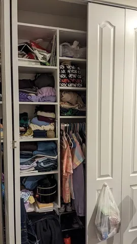 a view of walk in closet with clothes and shoes