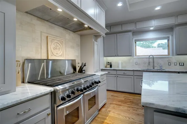 a kitchen with stainless steel appliances granite countertop a stove and a sink