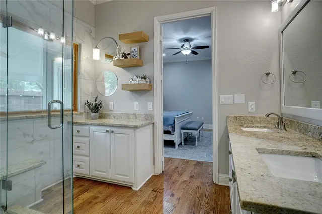 a en suite bathroom with a granite countertop sink and a mirror