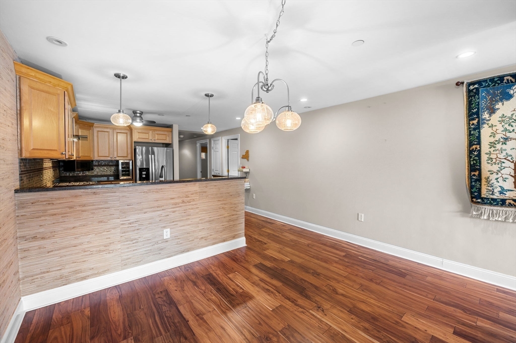 60 Merrimac Street, Unit 604 Amesbury, MA 01913 - Photo 10 of 42 a view of a kitchen with wooden floor and a ceiling fan