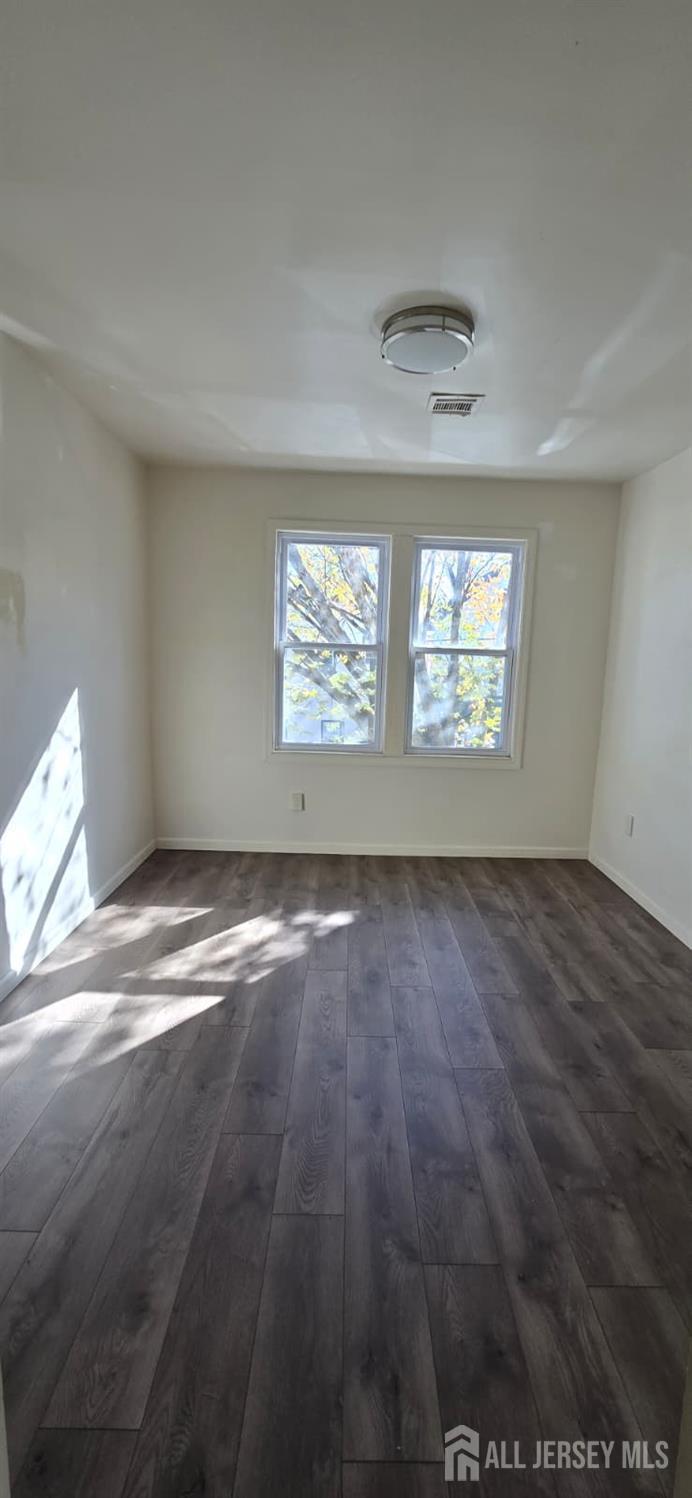 523 State Street Perth Amboy, NJ 08861 - Photo 14 of 22 an empty room with wooden floor and windows