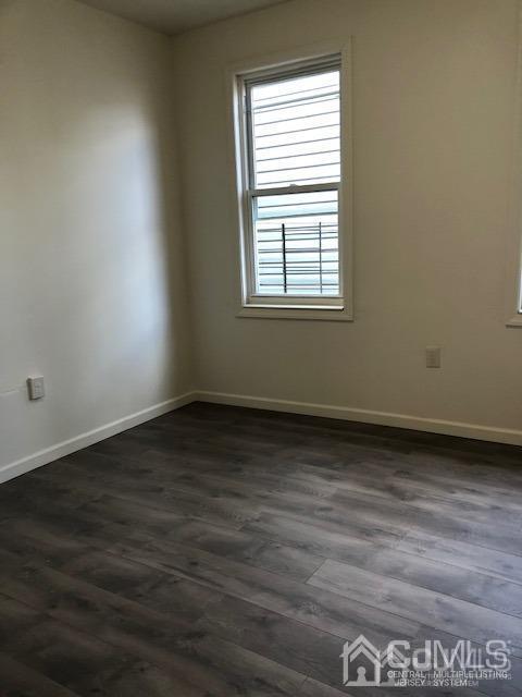 523 State Street Perth Amboy, NJ 08861 - Photo 6 of 22 an empty room with wooden floor and windows