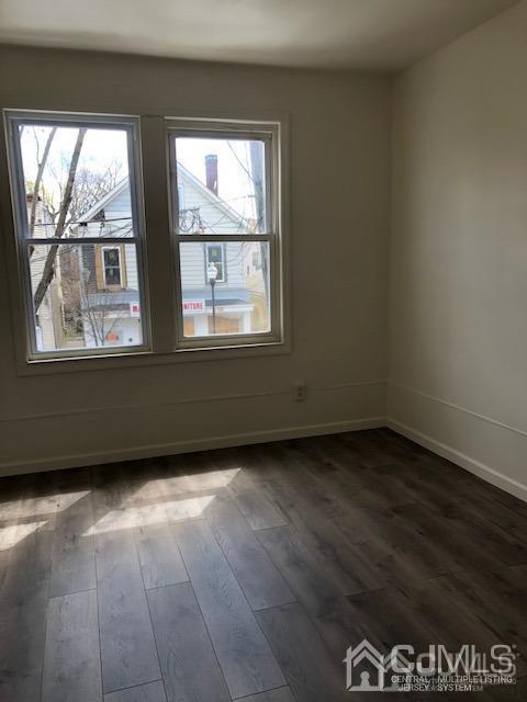 523 State Street Perth Amboy, NJ 08861 - Photo 7 of 22 an empty room with wooden floor and windows