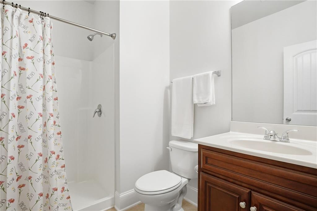 515 Sunset Street Canton, GA 30114 - Photo 38 of 64 a bathroom with a sink a toilet and shower curtain