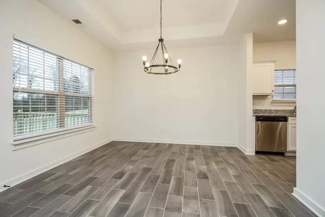 a view of a room with wooden floor kitchen view and a window