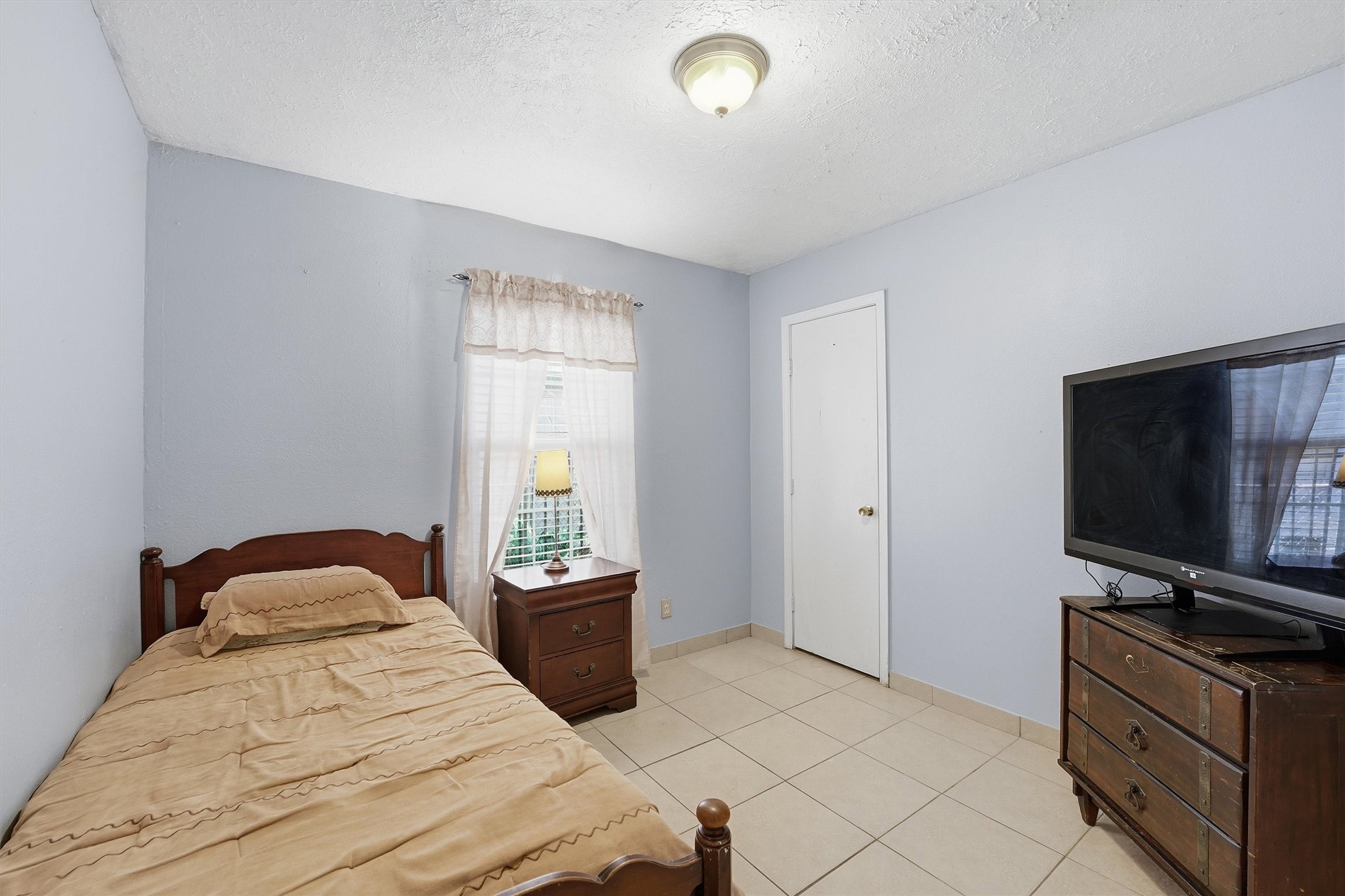 134 Obion Road Houston, TX 77076 - Photo 9 of 14 a bedroom with a bed and a flat screen tv