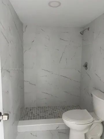 a bathroom with a toilet and a shower