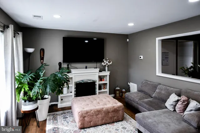 a living room with furniture a fireplace and a potted plant