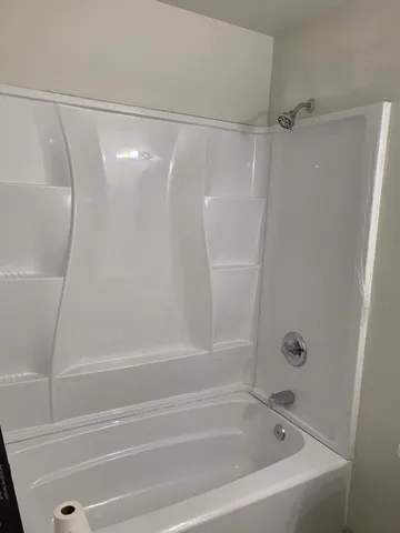 a bathroom with a shower and a bath tub