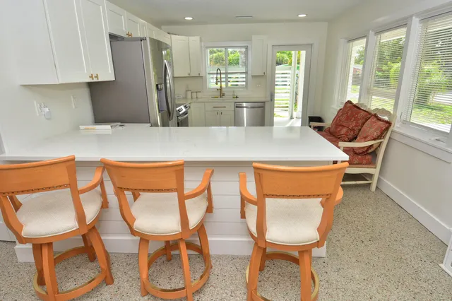 a dining room with furniture and a floor to ceiling window