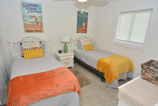 a bedroom with two beds and a window