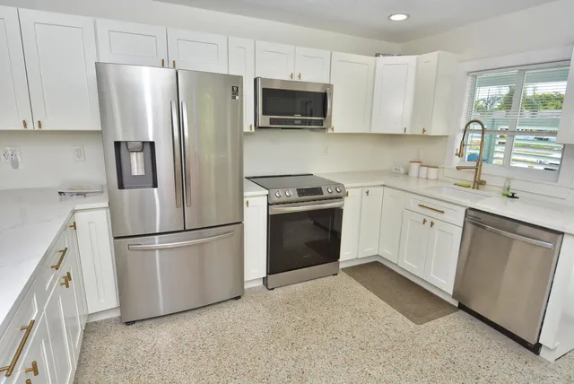 a kitchen with stainless steel appliances a refrigerator stove and sink