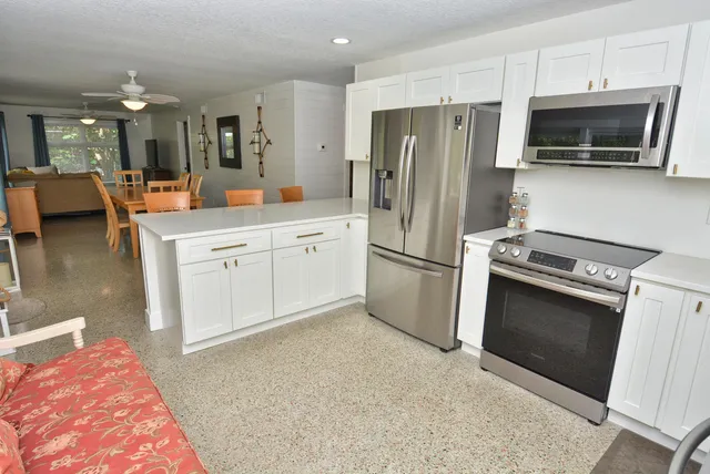 a kitchen with stainless steel appliances granite countertop a refrigerator stove and microwave