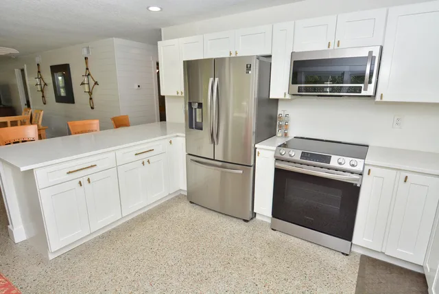 a kitchen with white cabinets and stainless steel appliances