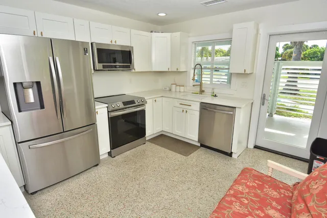 a kitchen with stainless steel appliances a refrigerator sink and microwave