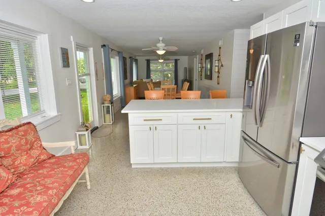 a kitchen with white cabinets and refrigerator