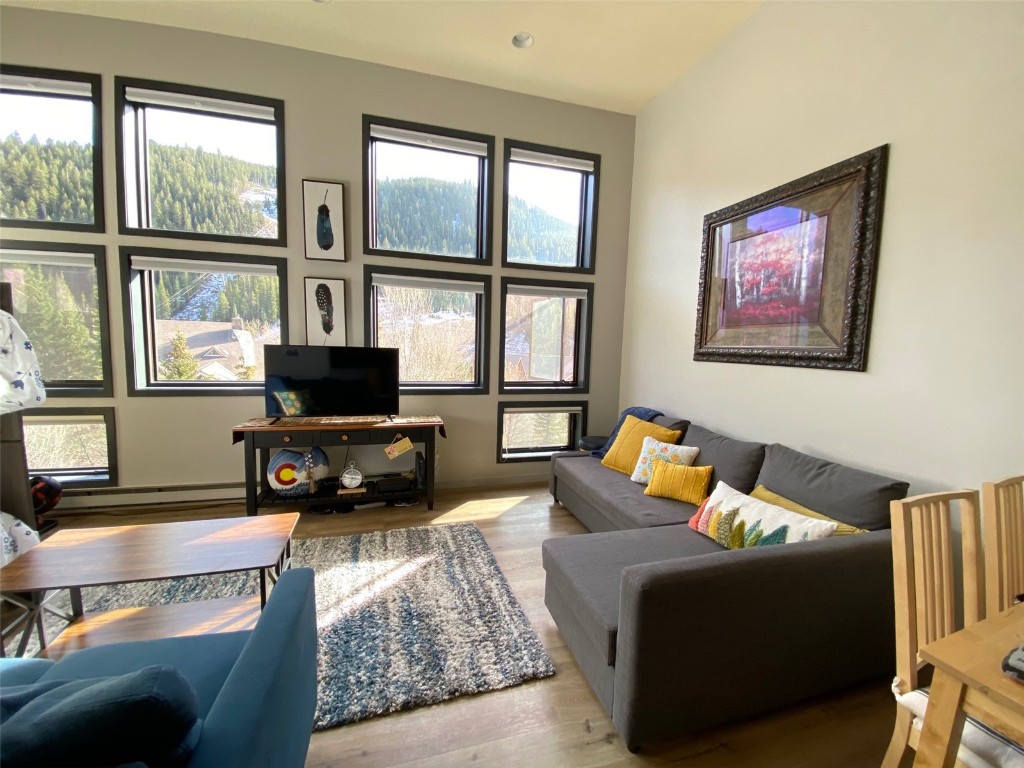 a living room with furniture a flat screen tv and a large window