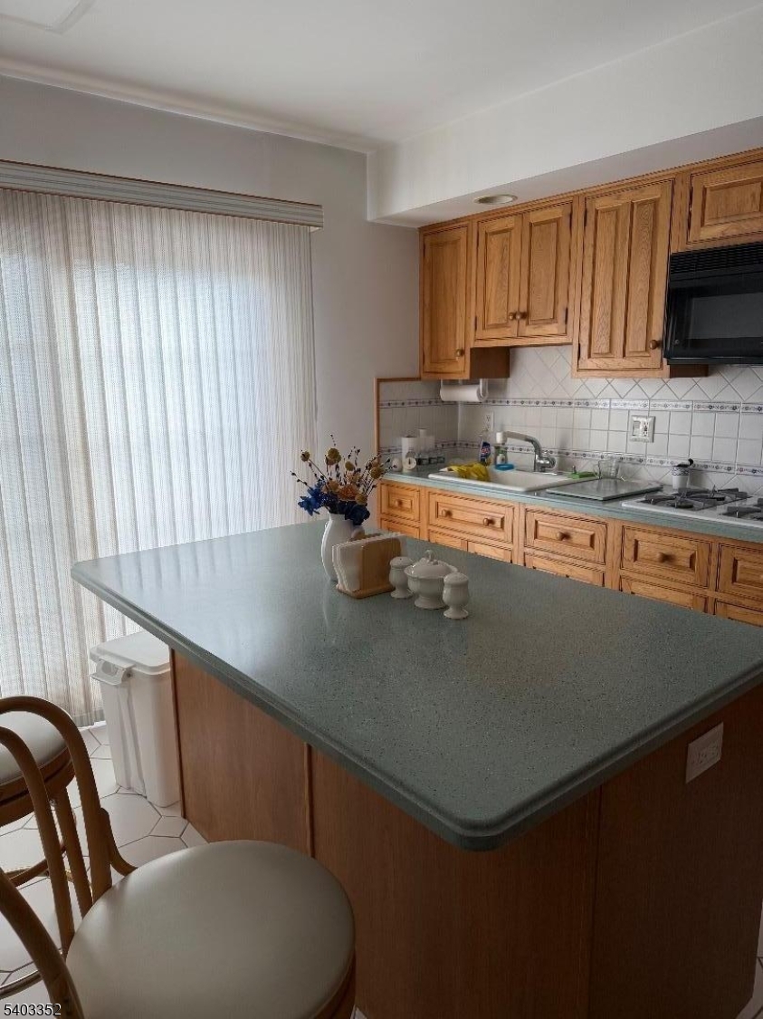 159 Wyoming Avenue Union, NJ 07083 - Photo 18 of 23 a kitchen with a sink a stove cabinets and a dining table