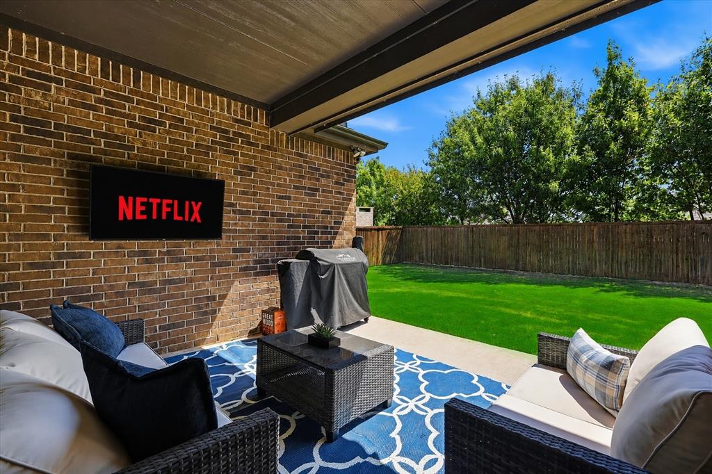 2908 Winding Ridge Court Oak Point, TX 75068 - Photo 29 of 38 Covered patio featuring a ceiling fan, brick wall, and a mounted television