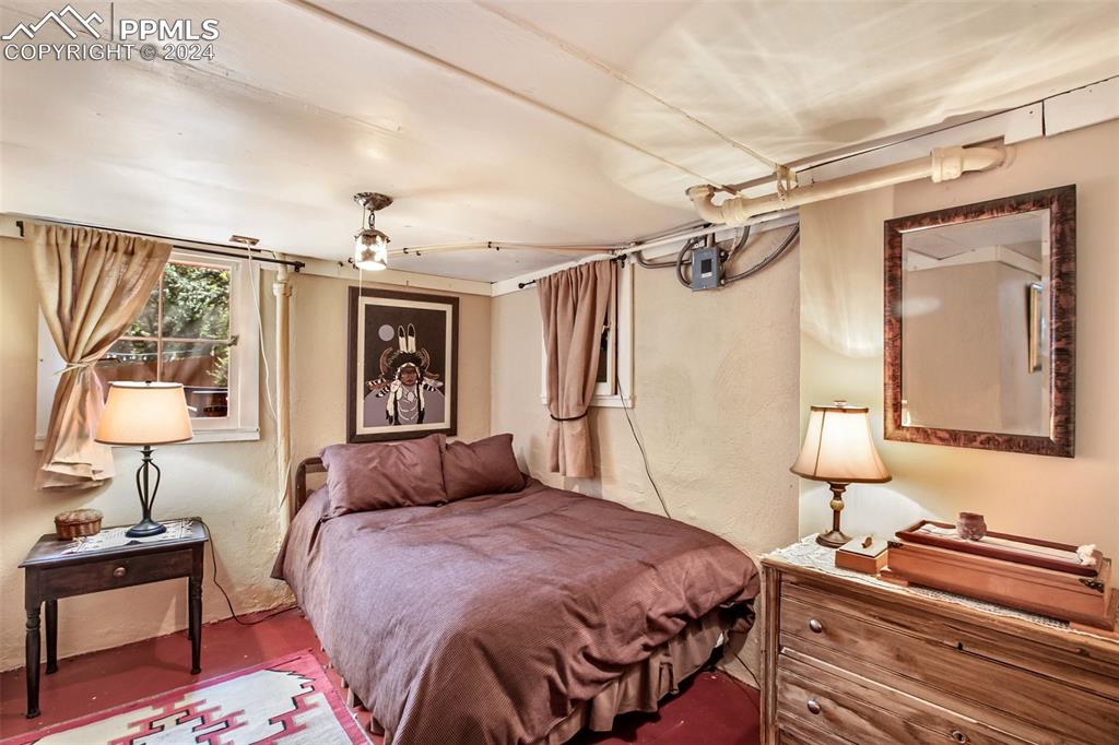 6015 Sioux Trail Cascade, CO 80809 - Photo 33 of 50 a bedroom with a bed and a lamp on table