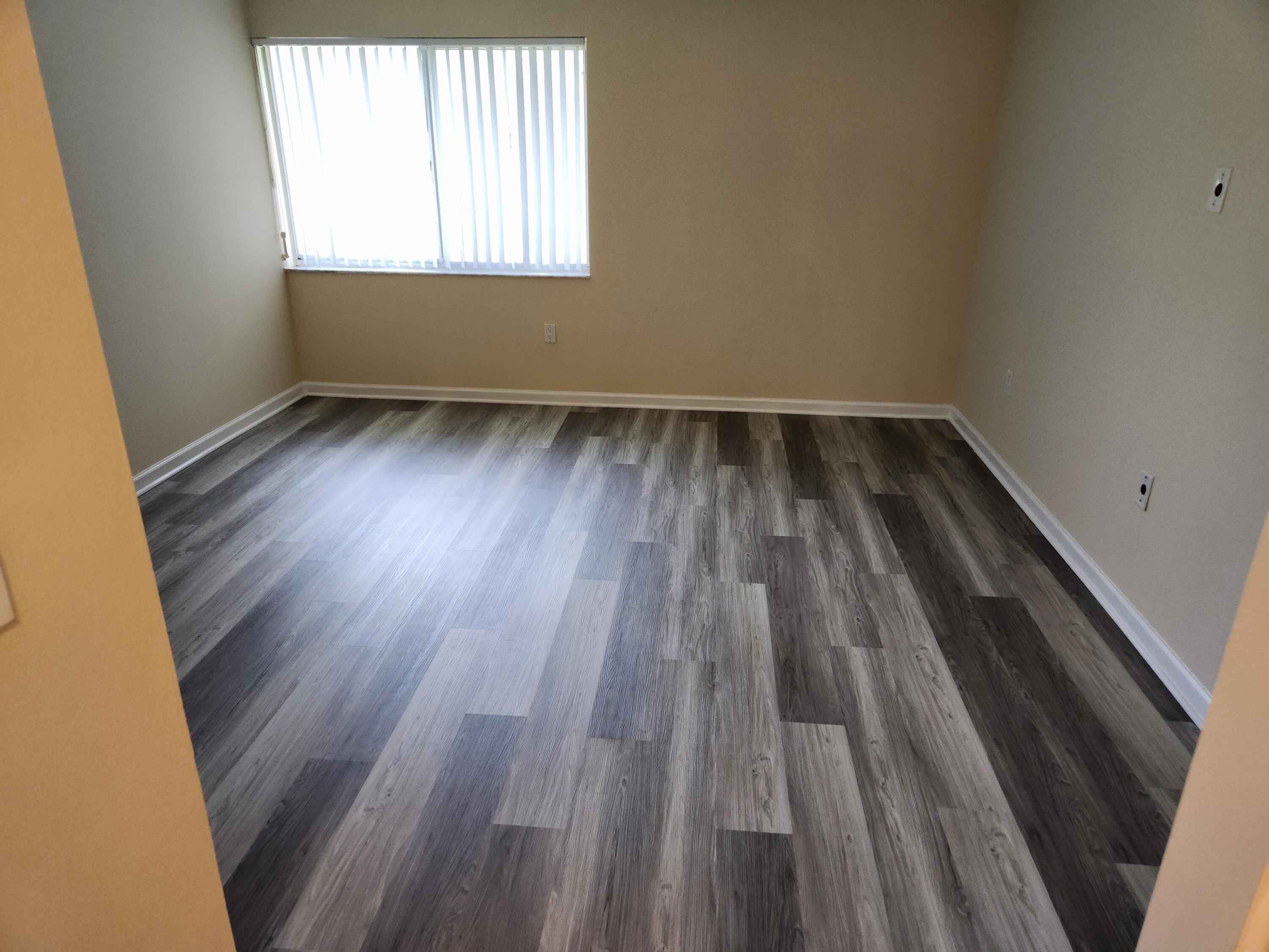 731 North Pine Island Road, Unit 402 Plantation, FL 33324 - Photo 7 of 11 an empty room with wooden floor and windows