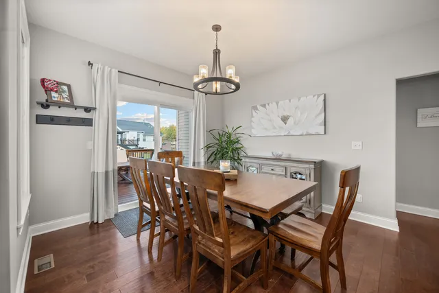 a kitchen with stainless steel appliances granite countertop a refrigerator a stove top oven a sink dishwasher and white cabinets with wooden floor