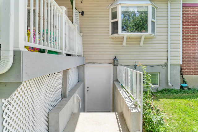 1489 North 400 West Bountiful, UT 84010 - Photo 38 of 47 Concrete pathway leading to a white door, featuring a white metal handrail and privacy lattice