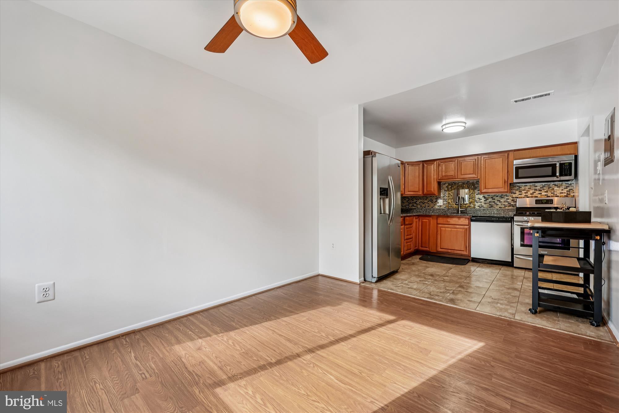 14428 Parkvale Road, Unit 3 Rockville, MD 20853 - Photo 16 of 37 a kitchen with stainless steel appliances kitchen island granite countertop a refrigerator and a stove top oven