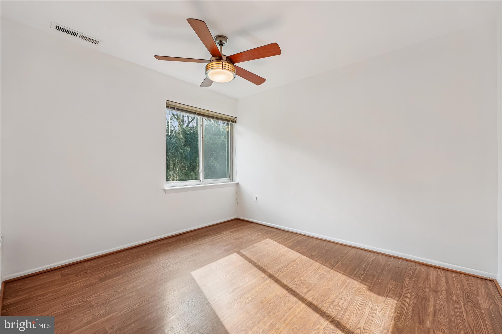 14428 Parkvale Road, Unit 3 Rockville, MD 20853 - Photo 18 of 37 an empty room with wooden floor fan and windows