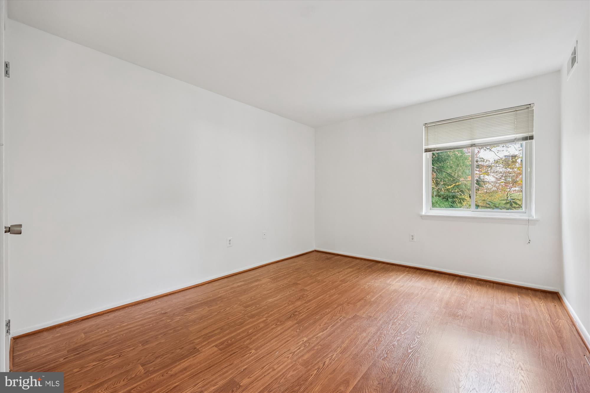 14428 Parkvale Road, Unit 3 Rockville, MD 20853 - Photo 24 of 37 an empty room with wooden floor and windows