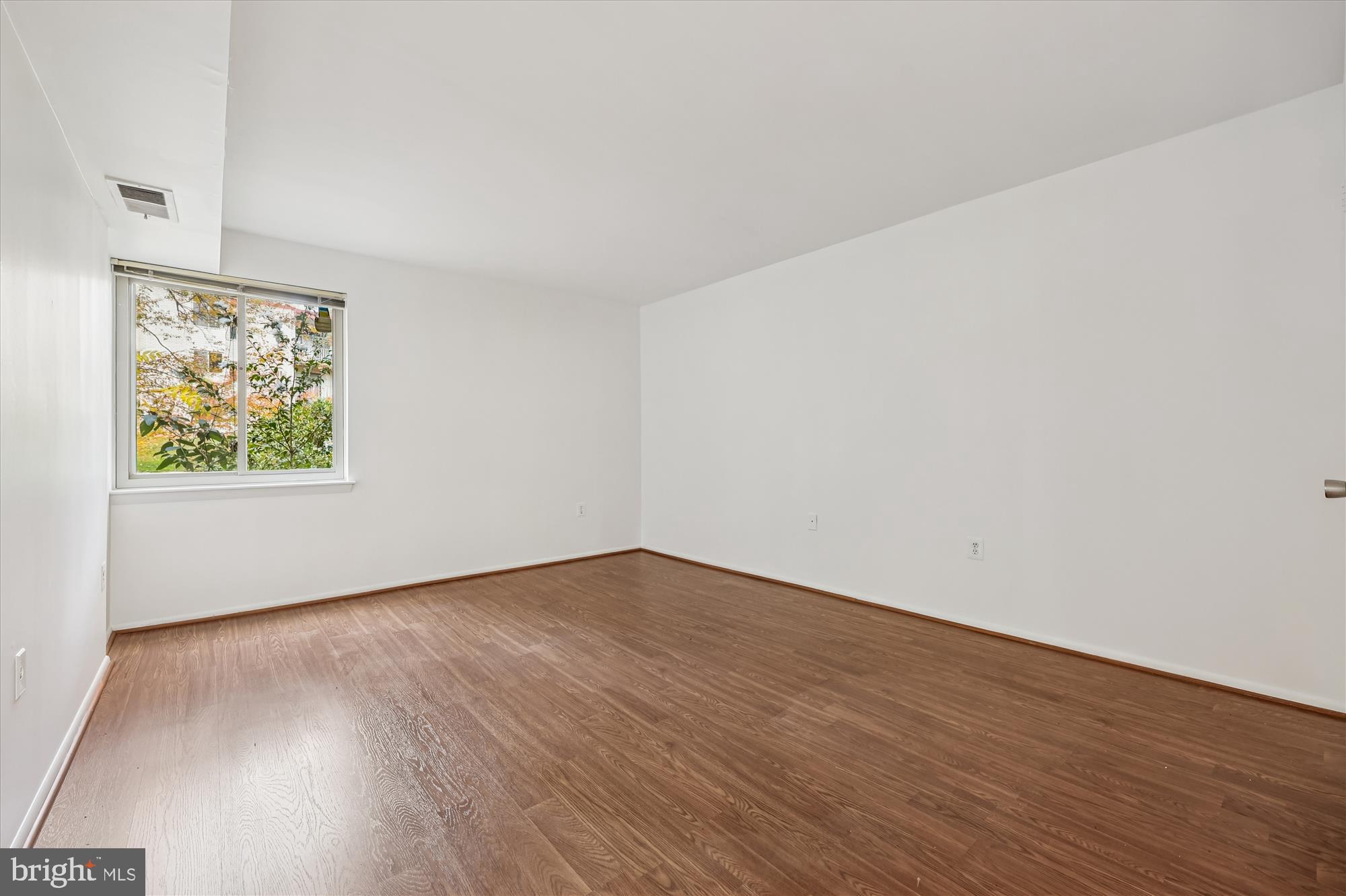 14428 Parkvale Road, Unit 3 Rockville, MD 20853 - Photo 28 of 37 an empty room with wooden floor and window