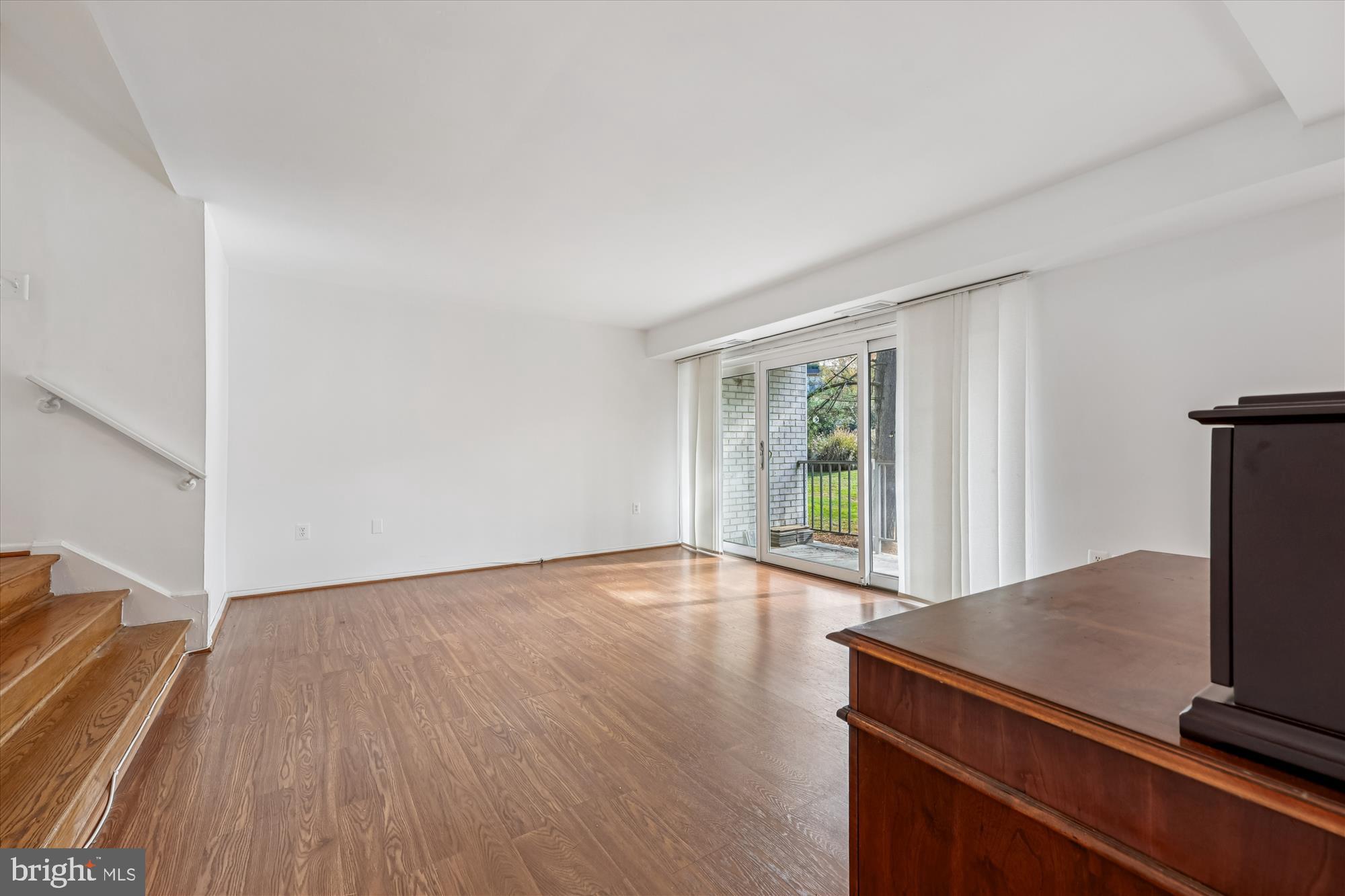 14428 Parkvale Road, Unit 3 Rockville, MD 20853 - Photo 9 of 37 a view of an empty room with wooden floor and a window
