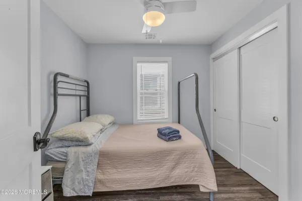 a bedroom with a bed and wooden floor
