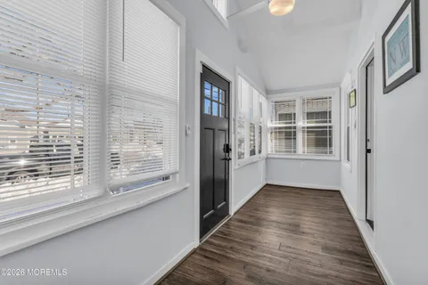 a view of a hallway with wooden floor and a window