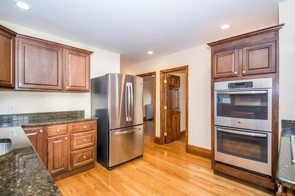 a kitchen with granite countertop stainless steel appliances a refrigerator and cabinets
