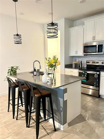 a kitchen with stainless steel appliances kitchen island granite countertop a sink a stove and a table