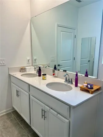 a bathroom with a double vanity sink and a mirror