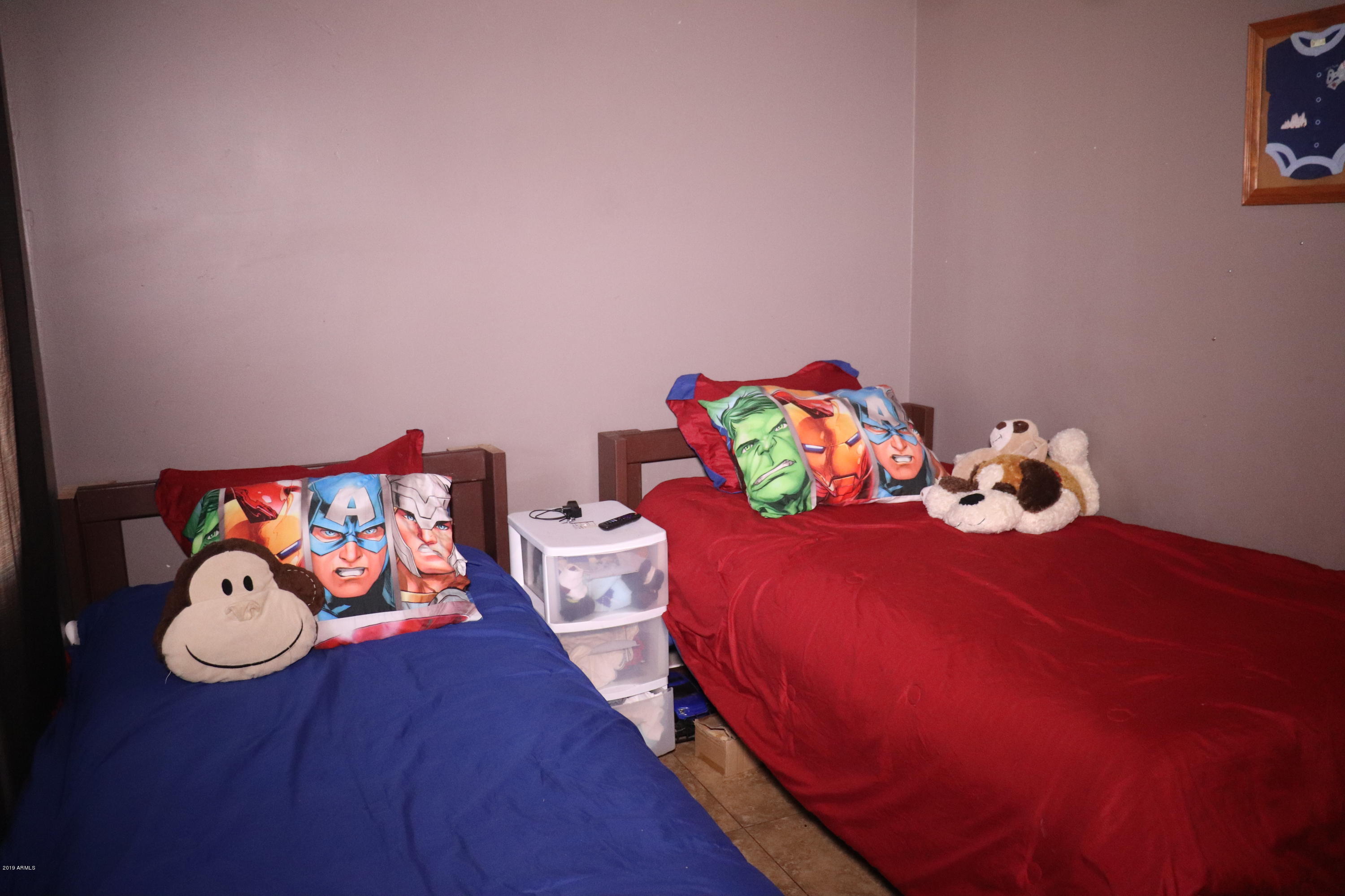 8233 West Osborn Road Phoenix, AZ 85033 - Photo 20 of 28 a bedroom with a bed and wooden floor