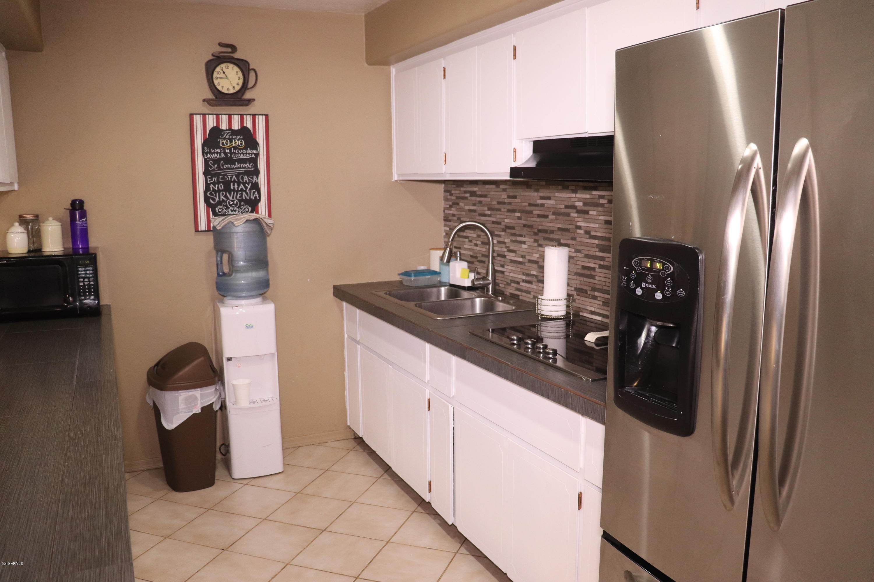 8233 West Osborn Road Phoenix, AZ 85033 - Photo 6 of 28 a kitchen with a refrigerator and cabinets