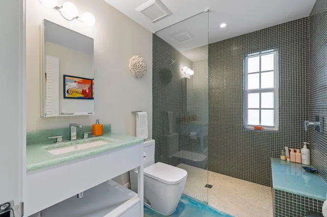 a bathroom with a sink a toilet and shower