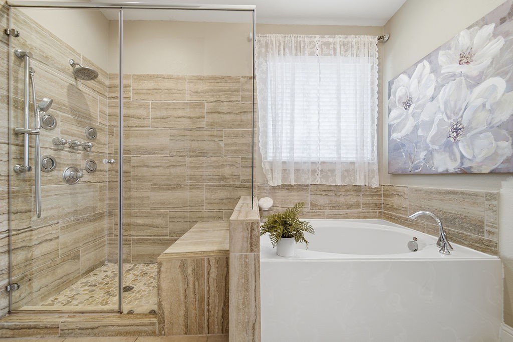 9614 Carson Lane Iowa Colony, TX 77583 - Photo 24 of 50 Elegant spa-like bathroom featuring a double-sink vanity, glass-enclosed shower, relaxing soaking tub with self-cleaning jets, and a stunning bubble chandelier that adds the perfect touch of luxury.