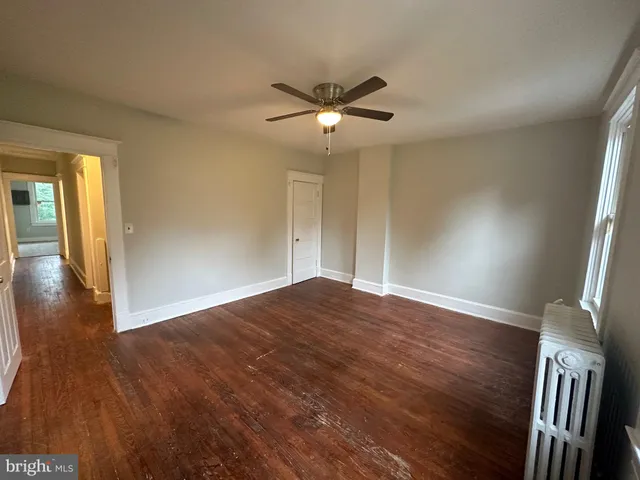 an empty room with a ceiling fan and wooden floor