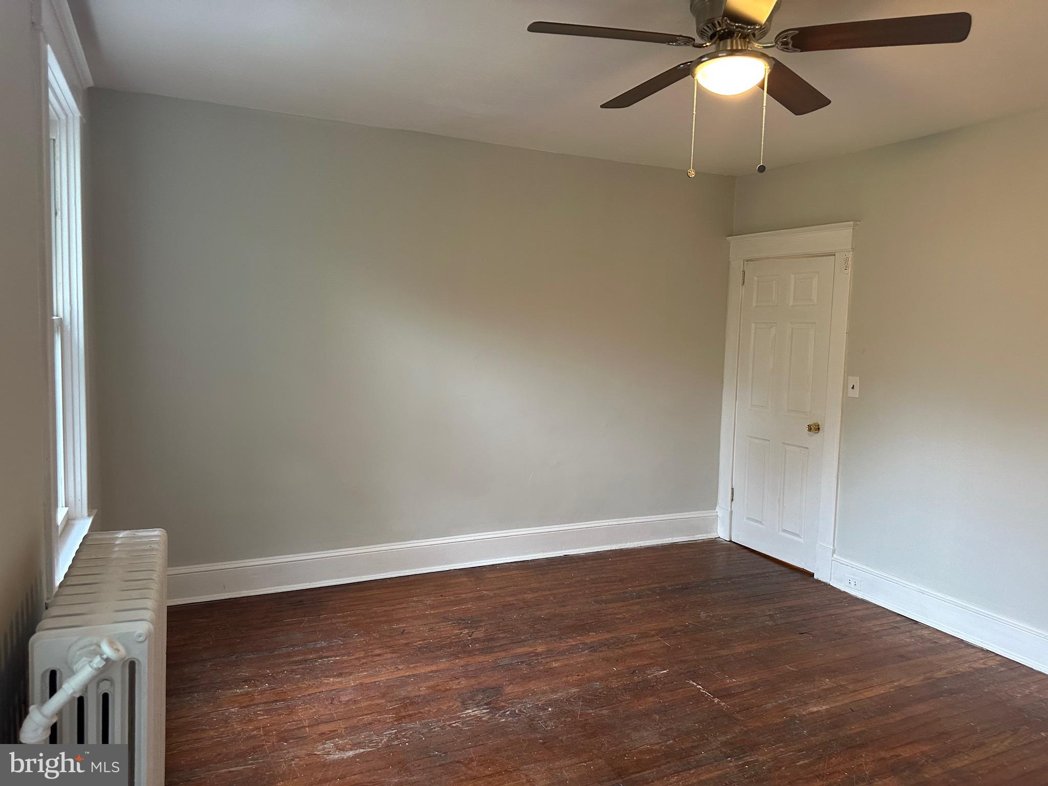 4227 Euclid Avenue, Unit B Baltimore, MD 21229 - Photo 20 of 87 an empty room with a ceiling fan and wooden floor